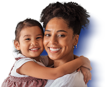 مادر در حالی که لبخند می زند دخترش را در آغوش می گیرد.